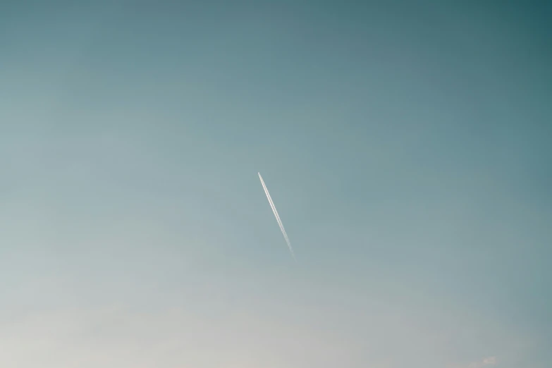 airplane contrail in the sky above some buildings