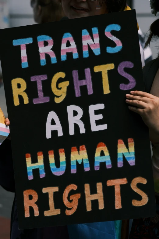 a group of people holding signs that say transs rights are human rights