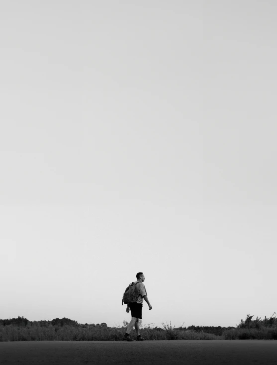 a man walking on top of a lush green field