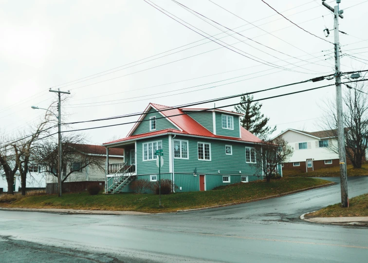 a view of an intersection with houses with a red roof and green siding