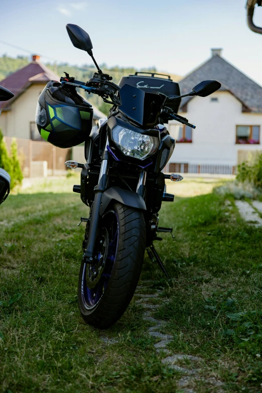 a black motorcycle parked in the grass outside