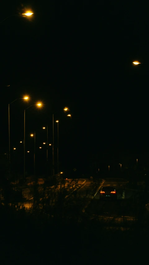 an image of street lights on an empty road at night