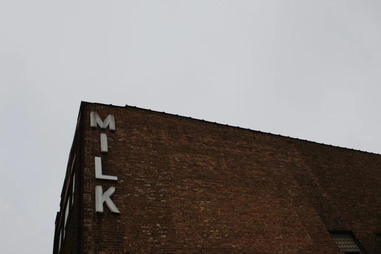 a close up of the words milk on the side of a building