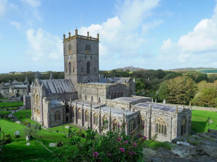 a large medieval style building on top of a lush green field