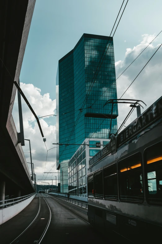 a very tall blue building by a set of train tracks