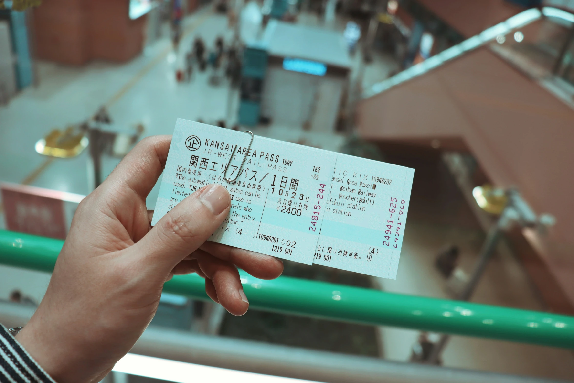 a person holds up a ticket for an airport