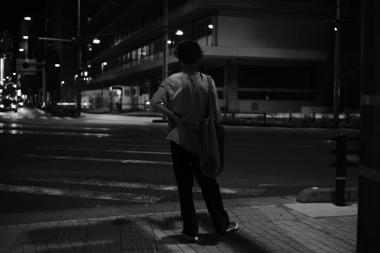 a person stands alone on the street corner