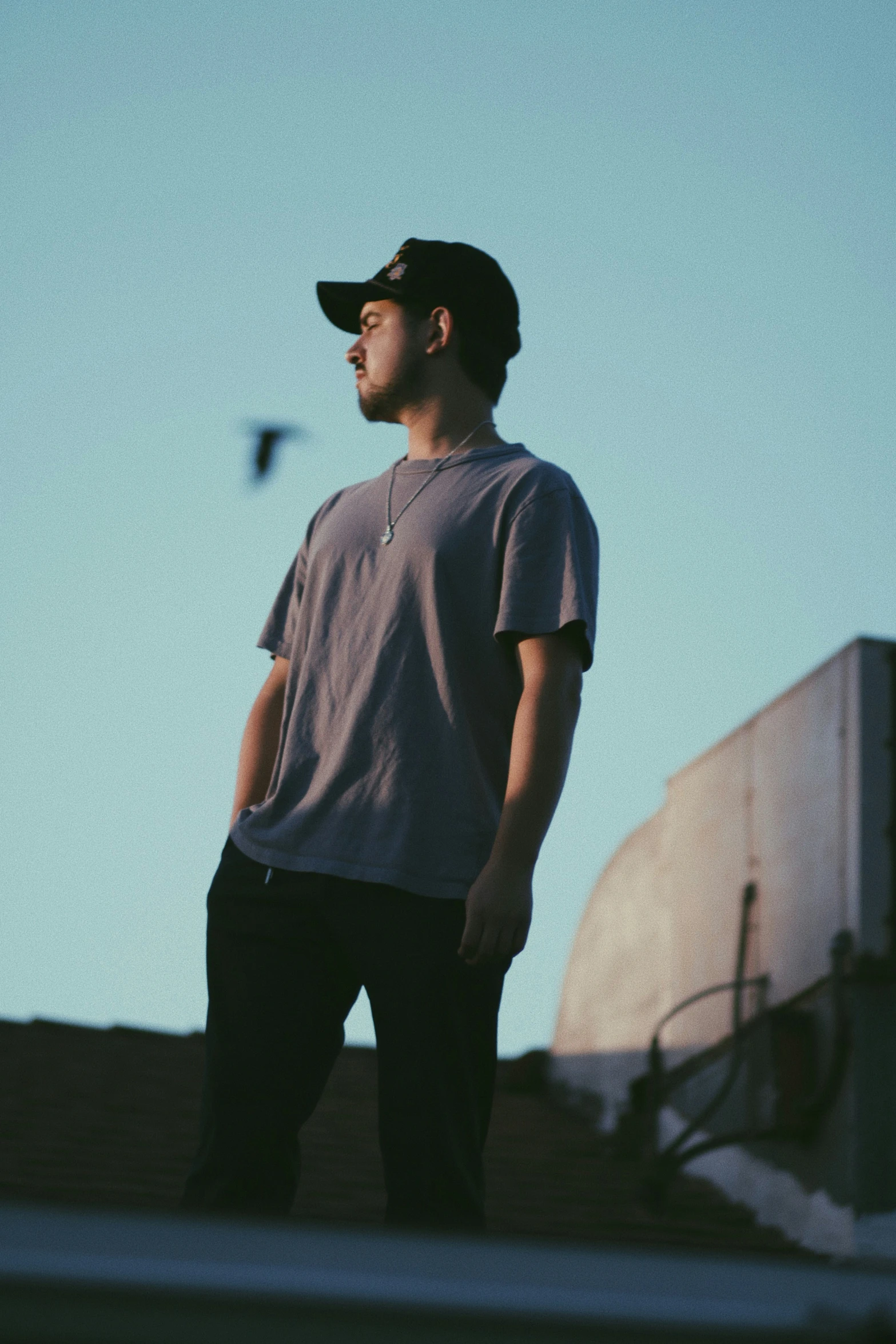 a man standing in the sun wearing a hat