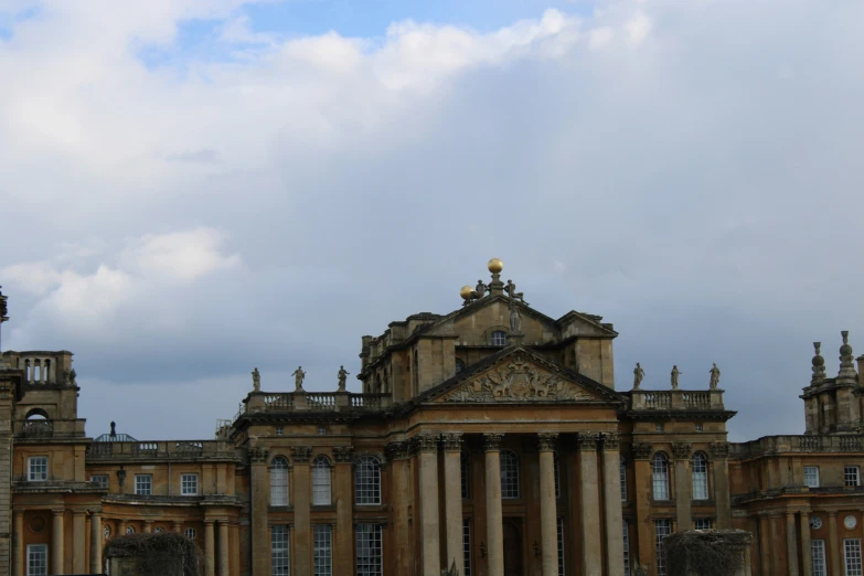 a tall building with many windows, an eagle statue on top