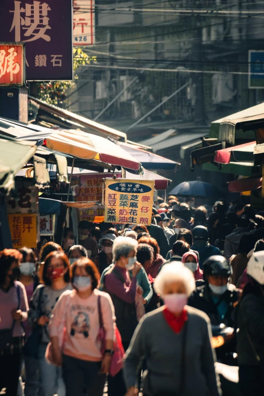 many people walk along a crowded street during the day