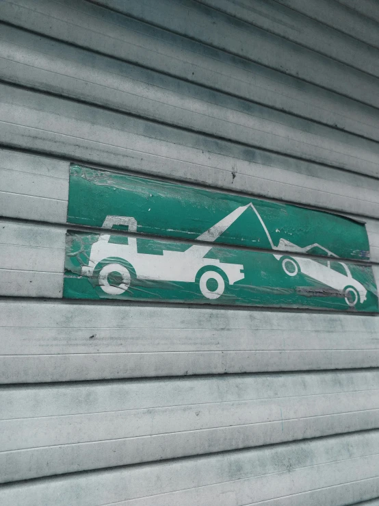 a green sign with a car and truck drawn on it