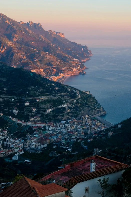 the view from a high altitude mountain above town with large mountains in the distance