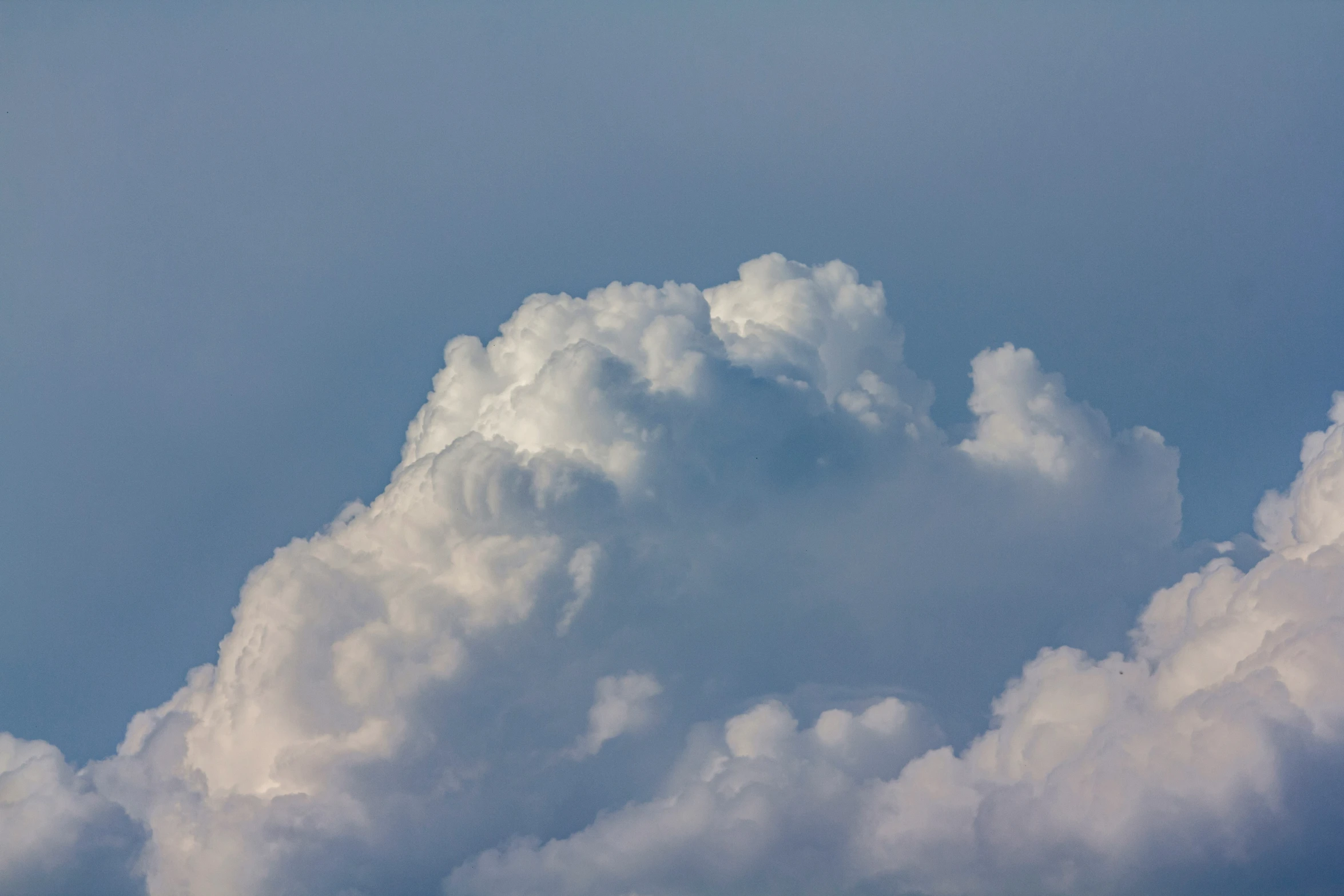 a jet airplane flying through a cloud filled sky