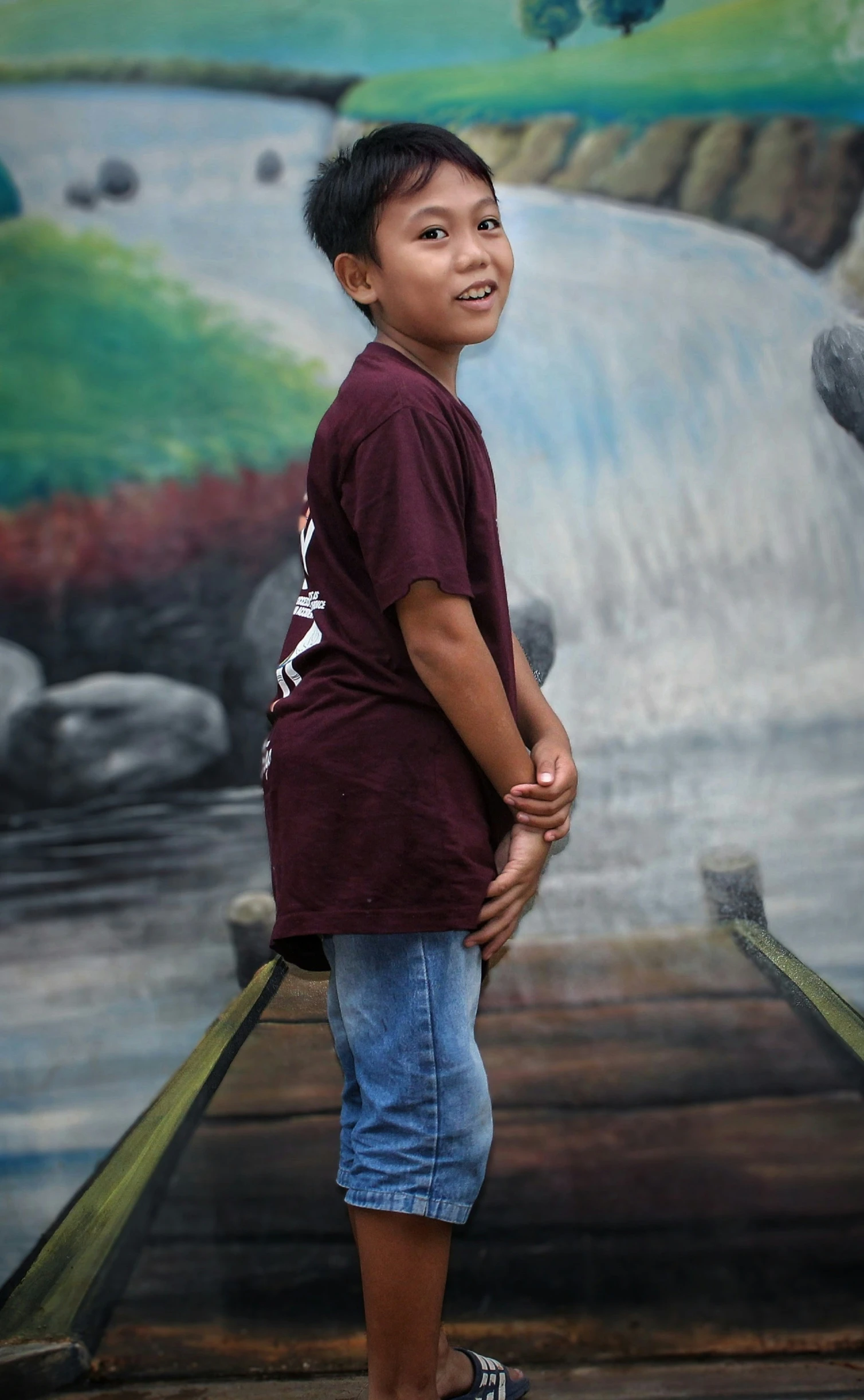 a boy standing by a colorful painted mural