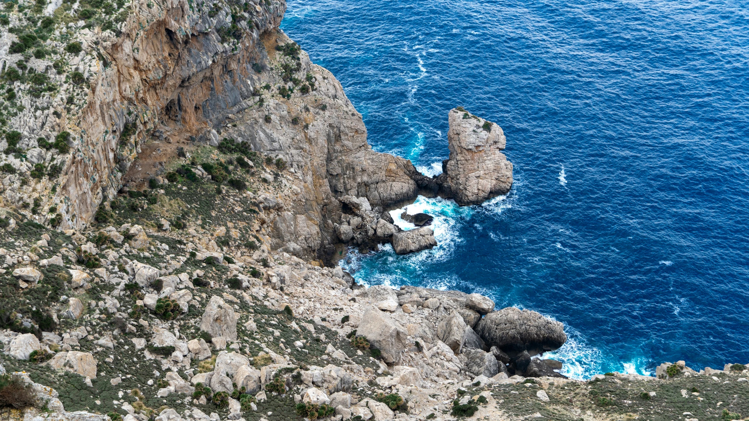 aerial view of rocky coast line and azure water