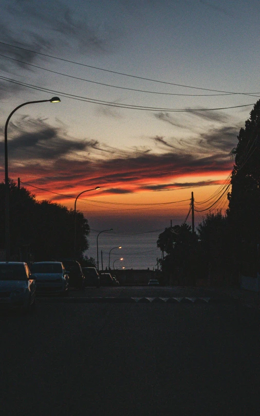 the sky is dark but red, with power lines above