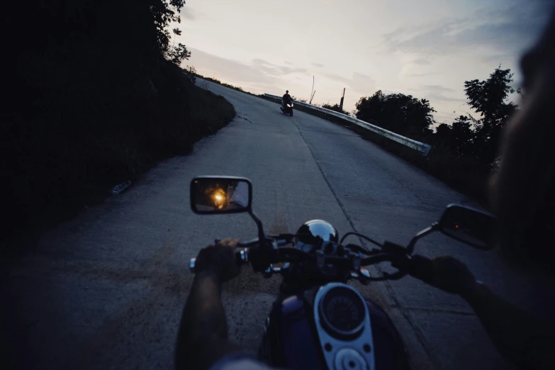 person riding a motorcycle at night with rear view mirror up