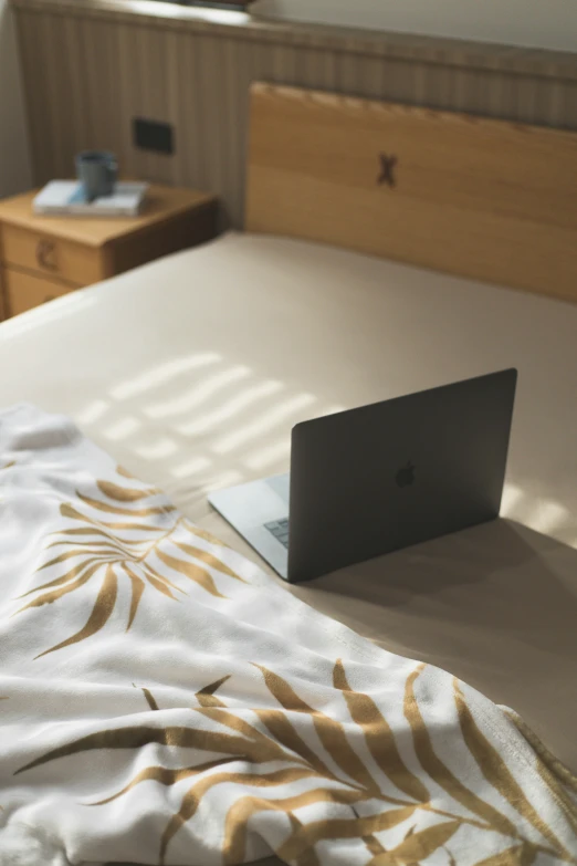 a laptop computer is on an unmade bed