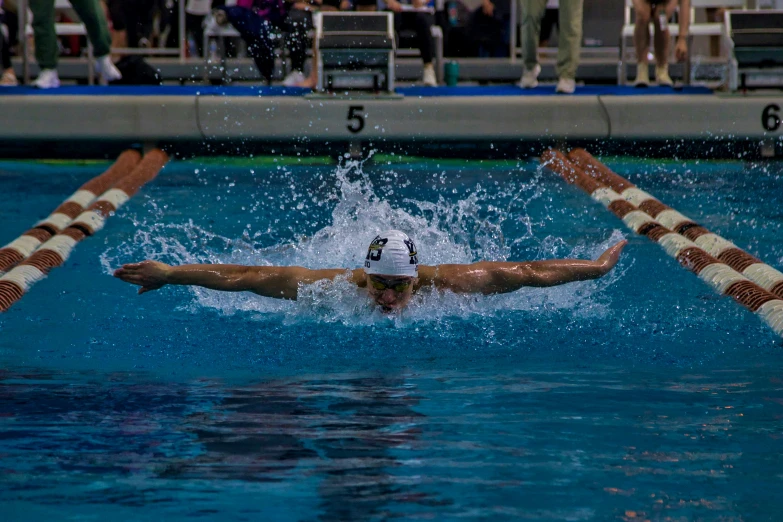 a man swimming in the pool with an outstretched arm