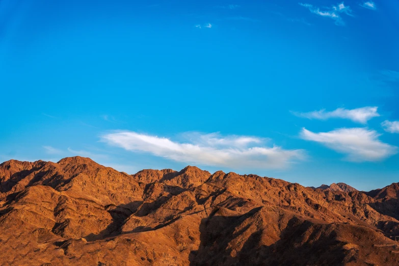 an airplane flies high in the sky above a mountain range