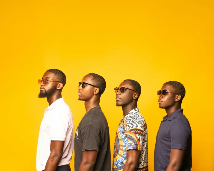 five black men stand against a yellow background