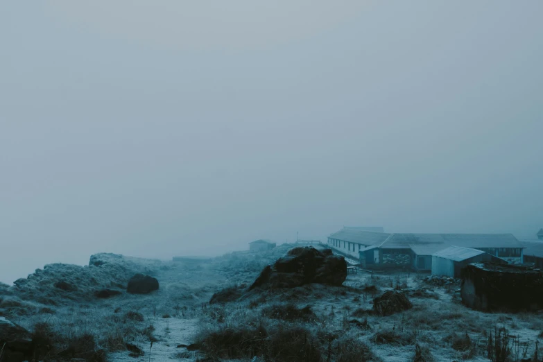 a hill with buildings on top, and a foggy sky