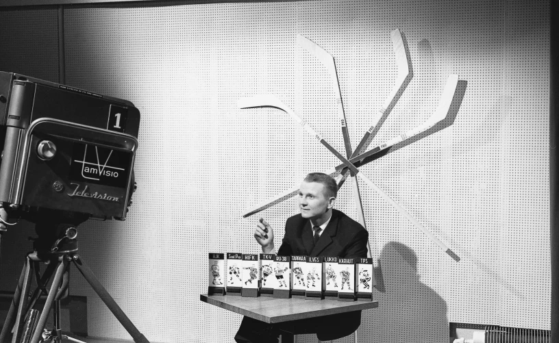 black and white po of a man at table with spider in room