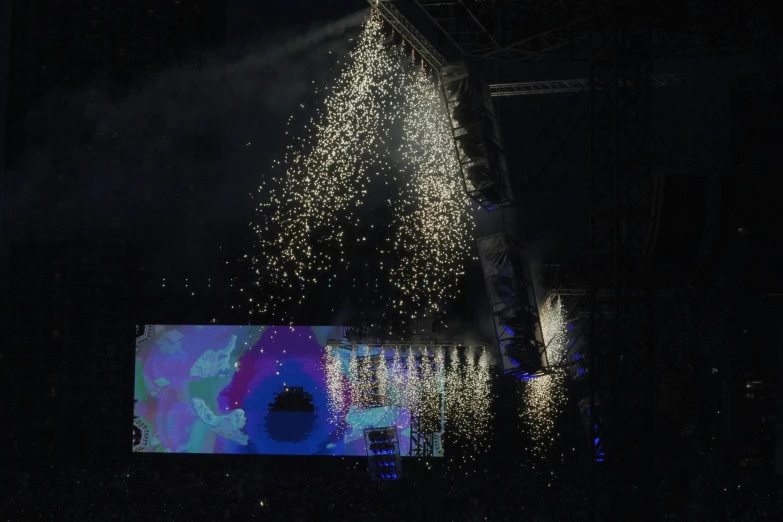 people watching fireworks on stage in the dark