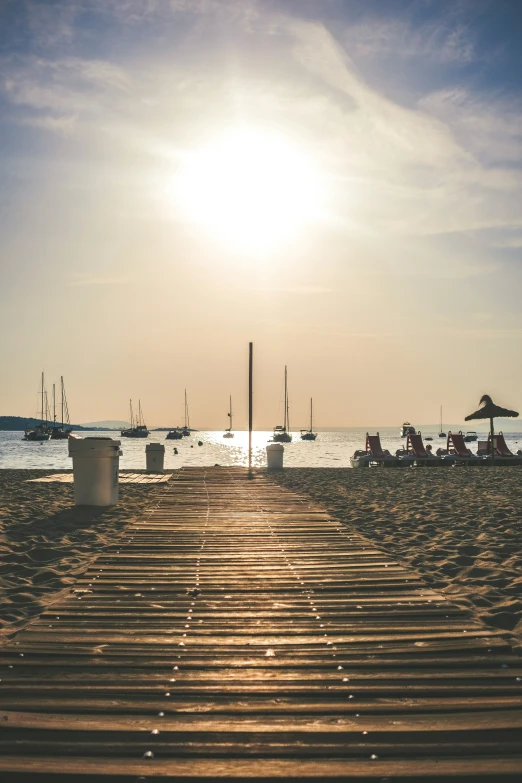 the sun shines brightly over the beach as people stand on the beach