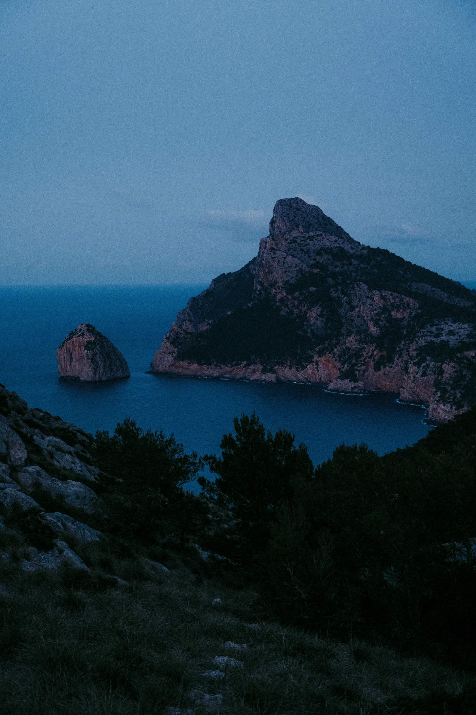 a body of water sitting next to a rocky island