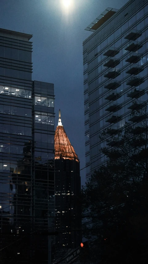 the moon rises above a building at night