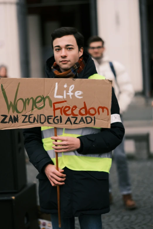 the man is holding a sign during a demonstration