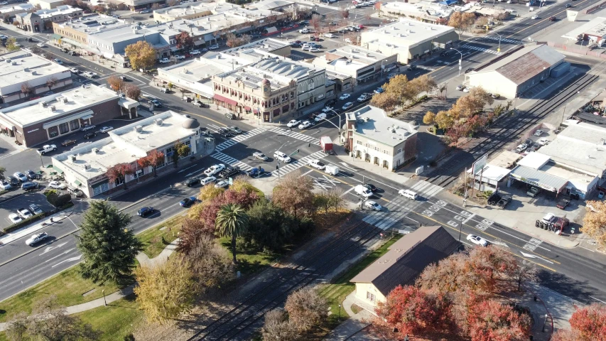 a city street with buildings on both sides and a train track in the center