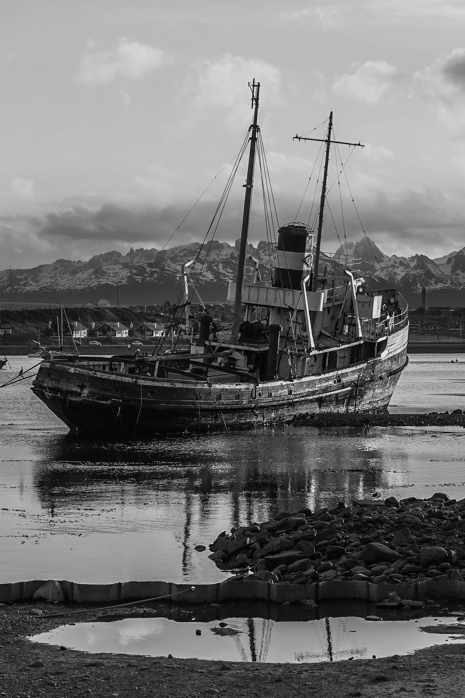 an old boat is docked along the shore