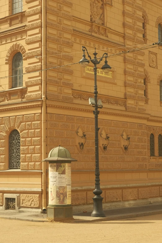 a tall brown brick building with street lamps on the corner