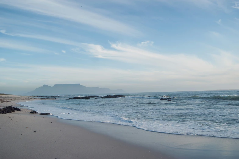 there are waves crashing to the shore of the beach