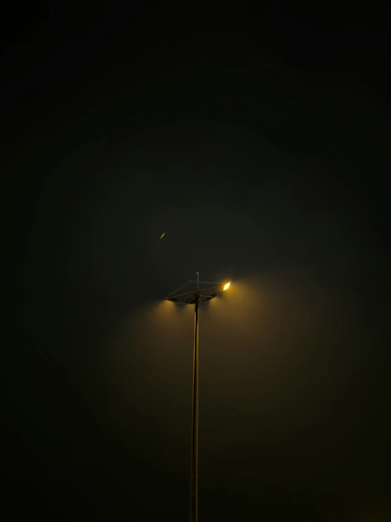 a lit up lamp on the ground in a dark room