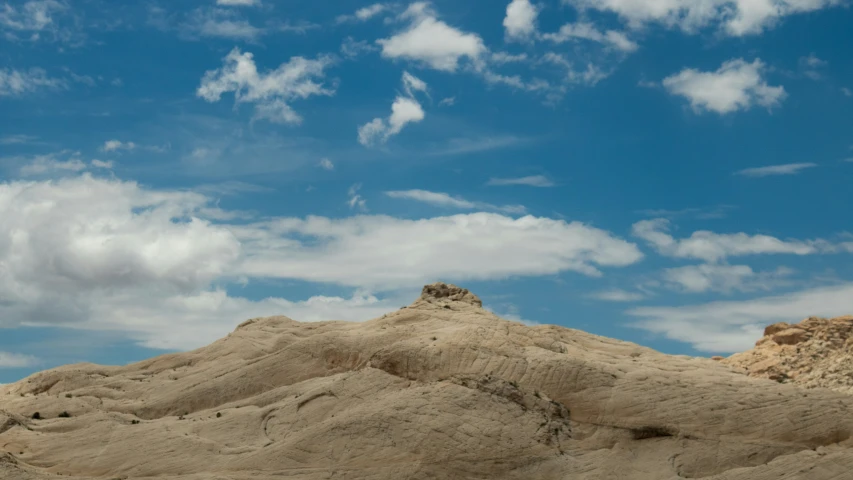 a very tall hill sitting on top of a sandy beach