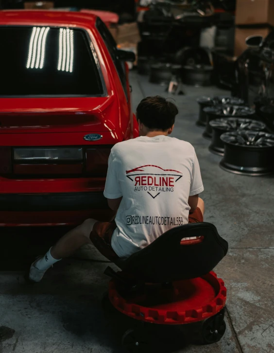 man fixing a wheel in front of a red truck