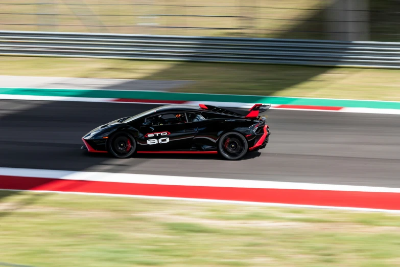 a car going down a race track with grass in front