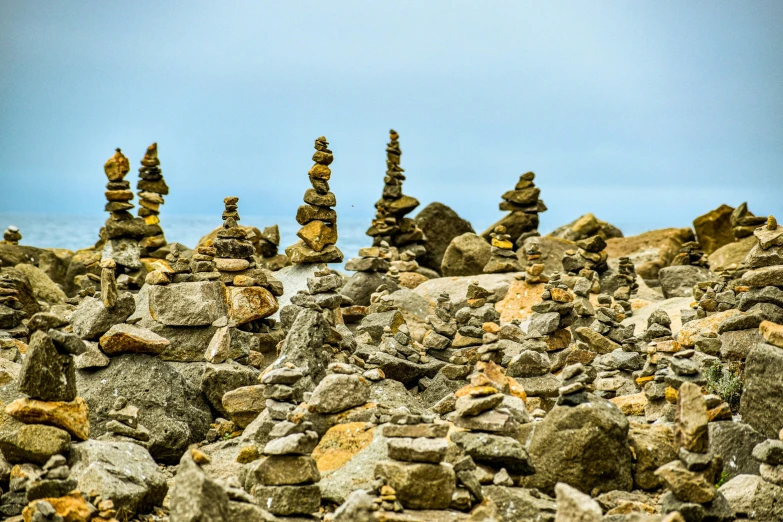 several rocks are arranged in a pyramid on a rocky beach