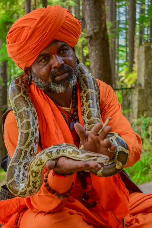 a man with a large snake on his arm