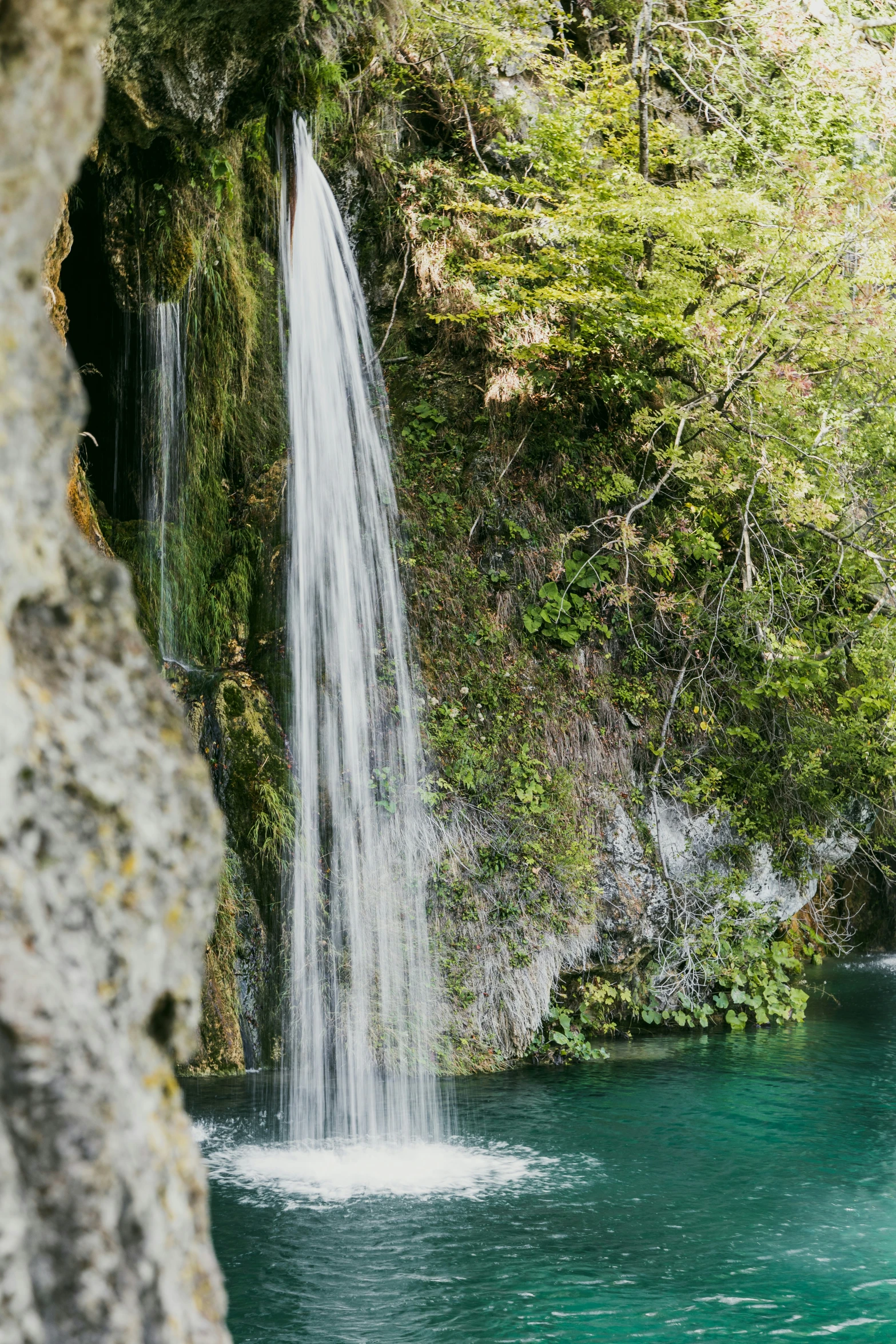 there is a tall waterfall sticking out of a lake