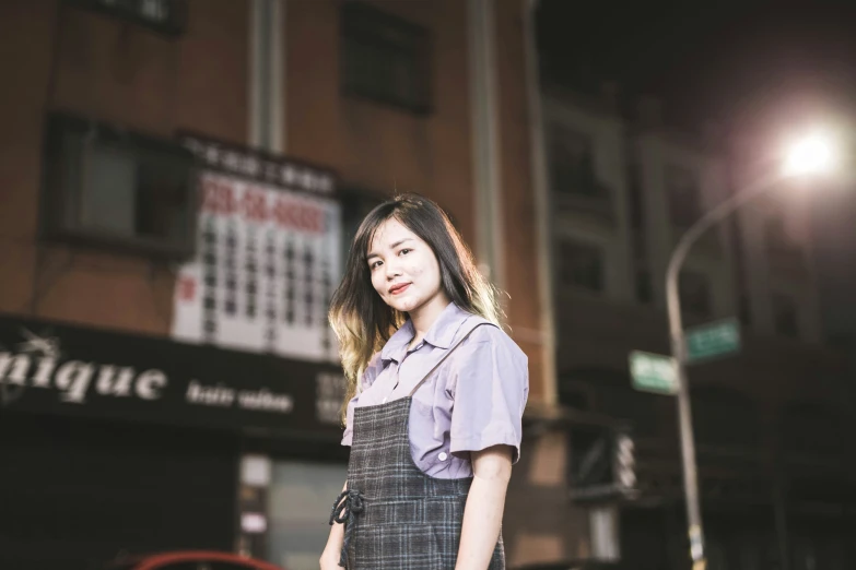 a woman stands on the street with her hands in her pockets