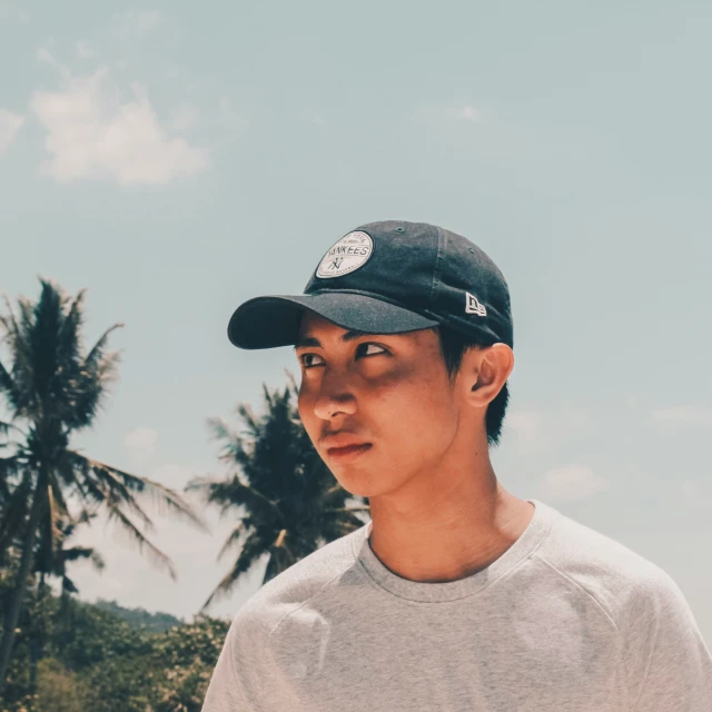 a man wearing a hat looking up at the sky