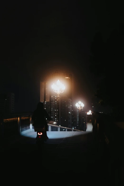 people walking down the sidewalk at night with illuminated buildings