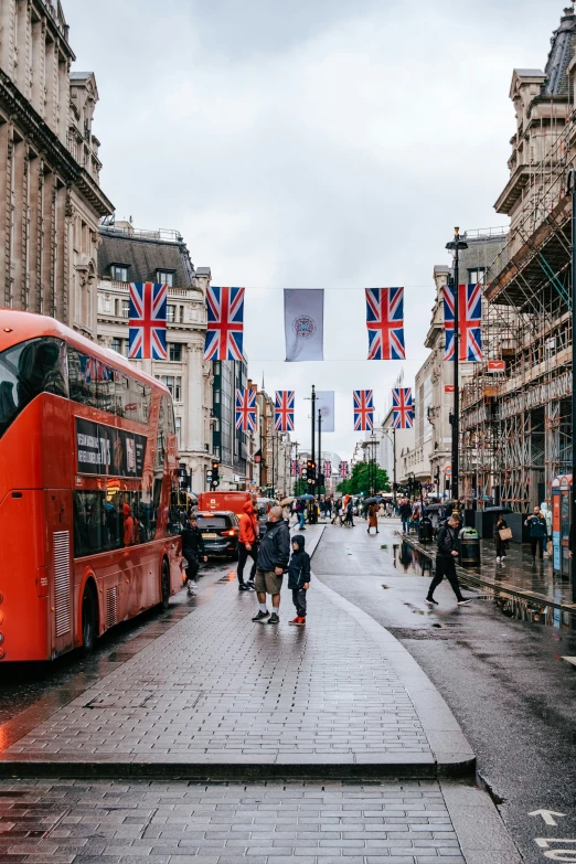 several red double decker buses parked on a street