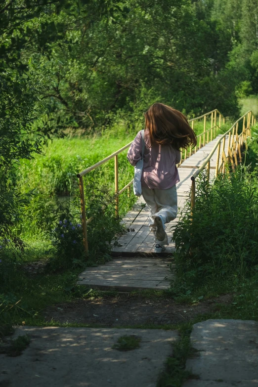 a girl walking up a wooden stairs holding on to her jacket