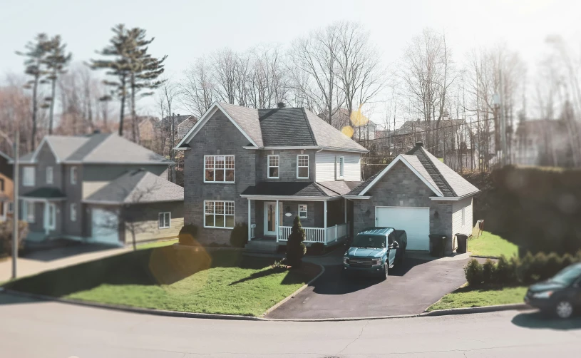 a home is shown from the street with cars parked in front of it