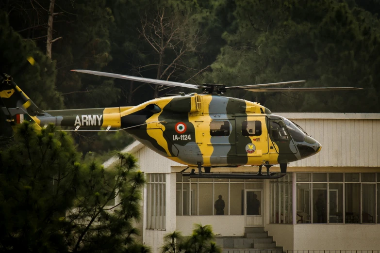 a black and yellow helicopter with trees in the background